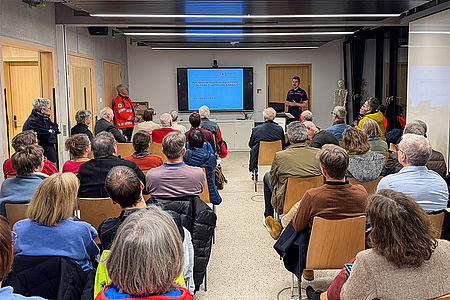 Mehrere Menschen sitzen in einem Schulungsraum beim DRK Biberach, zwei Referenten stehen vorne.