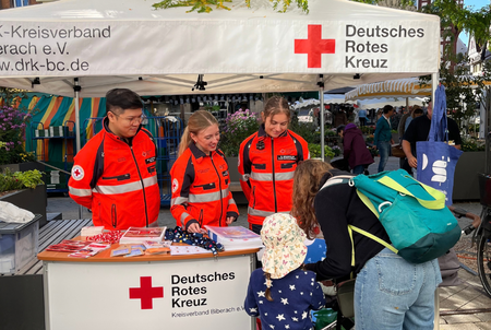 Eine Frau mit Kind an einem Info-Stand des DRK Biberach