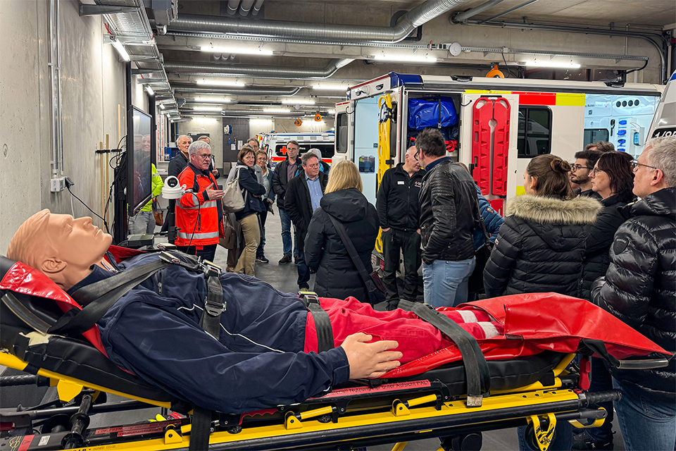 Mehrere Personen stehen in der Rettungswache Biberach, im Vordergrund ist eine Simulationspuppe zu sehen.