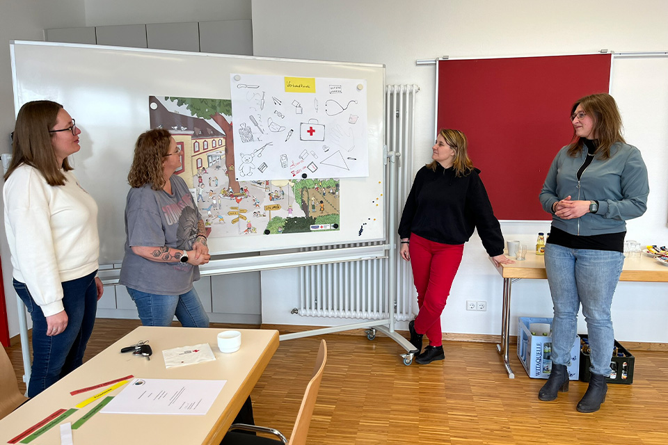 Vier junge Frauen vom DRK halten eine Präsentation