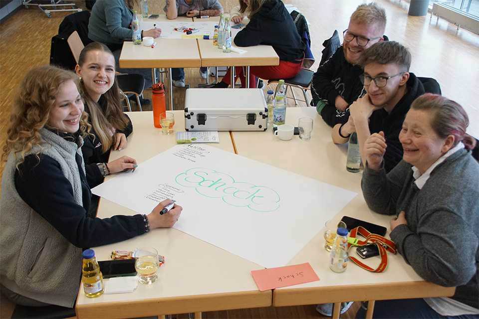 Mehrere Ehrenamtliche des DRK sitzen bei einer Gruppenarbeit