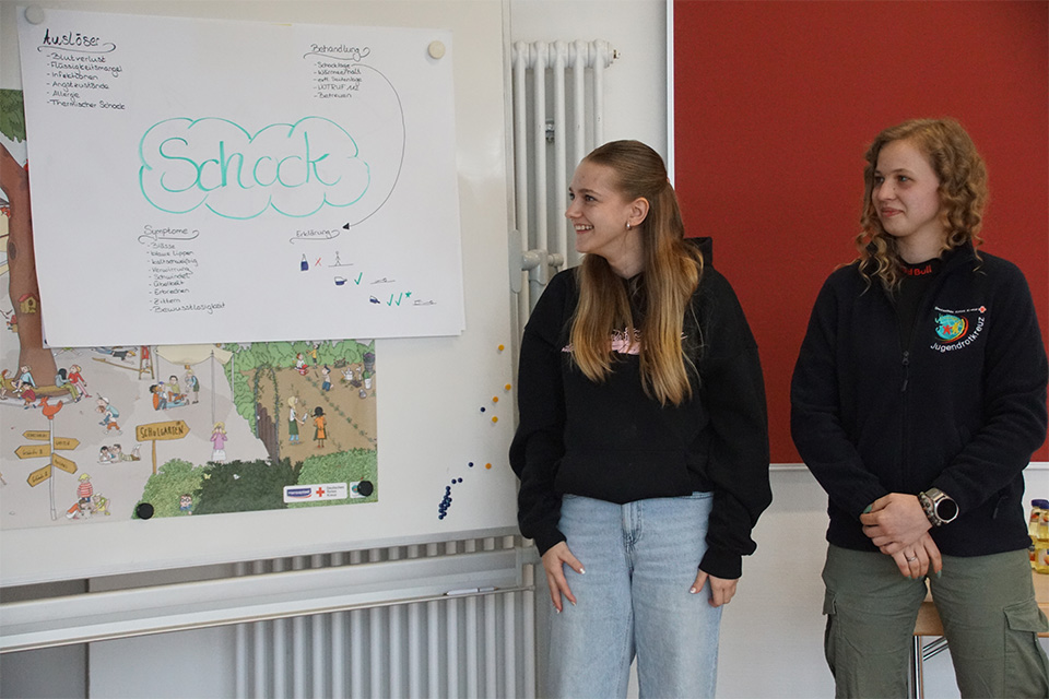 Zwei junge Frauen vom DRK halten eine Präsentation