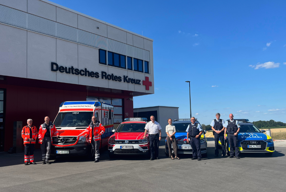 Sicherheitskonzept Schützen Mehrere Einsatzfahrzeuge (Polizei, DRK) und Einsatzkräfte stehen vor der Leitstelle des DRK Biberach.