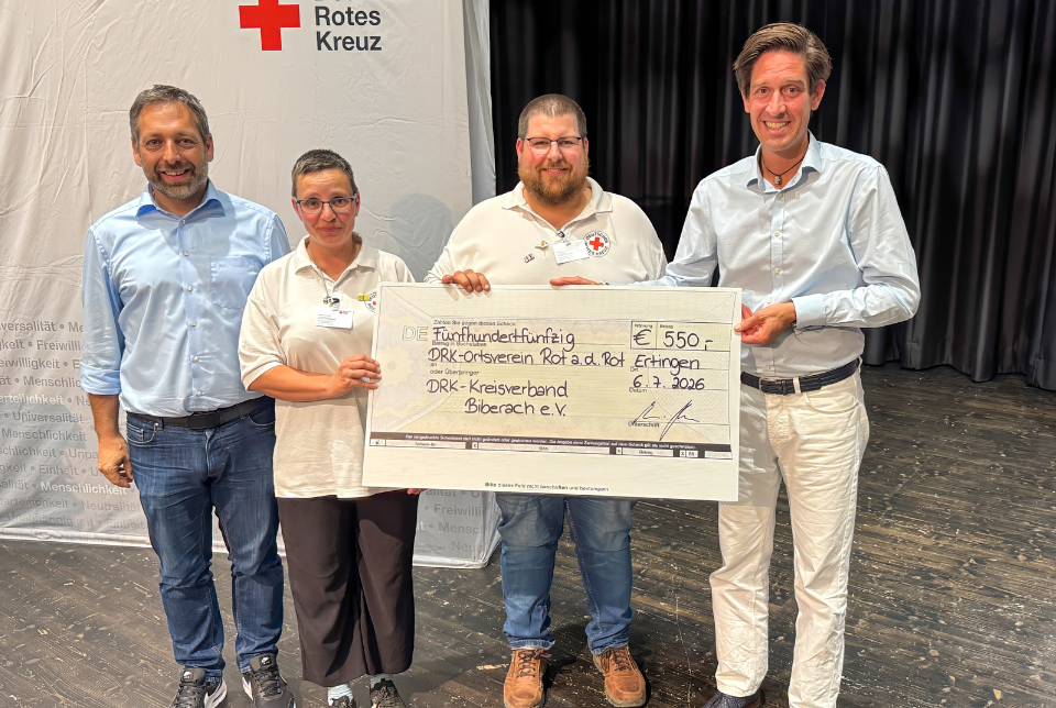 Ein Gruppenfoto mit vier Personen bei der DRK-Kreisversammlung