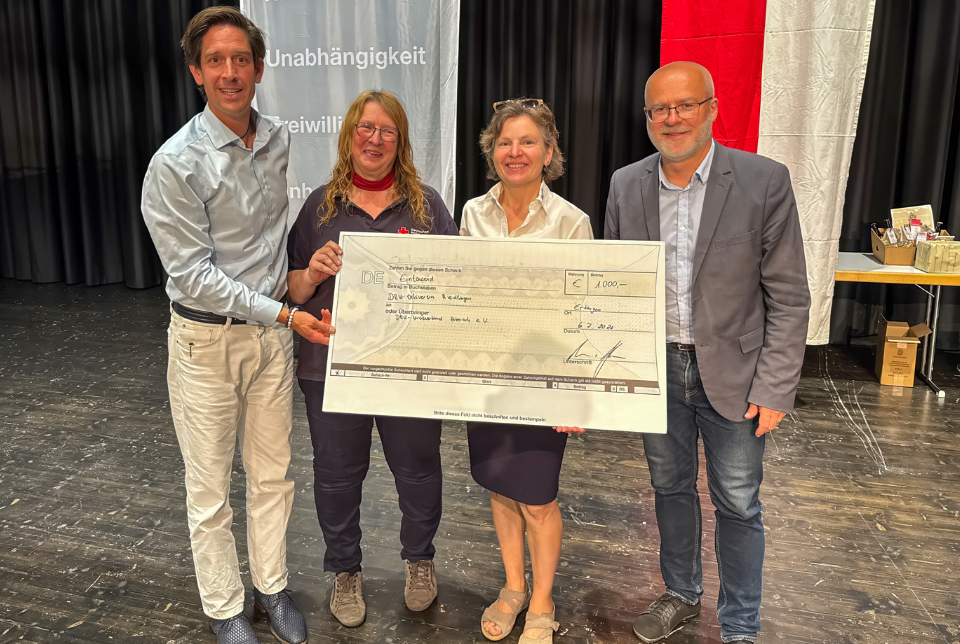 Ein Gruppenfoto mit vier Personen bei der DRK-Kreisversammlung