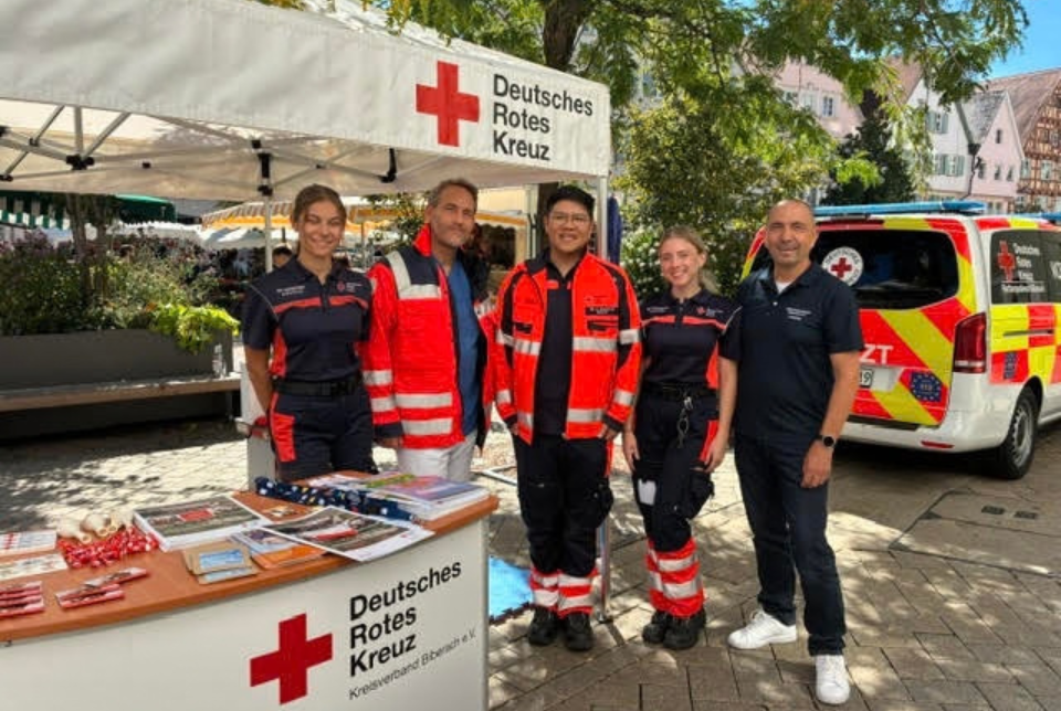 Woche der Wiederbelebung Mehrere Personen in DRK-Kleidung an einem Info-Stand