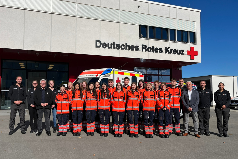 Eine Menschengruppe in DRK-Kleidung vor der Rettungswache Biberach.